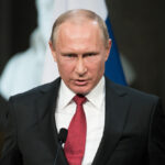 Vladimir Putin speaking at a press conference at the Palace of Versailles.