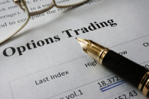 A pen pointing to the bolded phrase “Options Trading” in a newspaper.