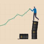 A man standing on oil barrels as energy stocks rise.