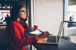 An account manager on the phone in front of a laptop.