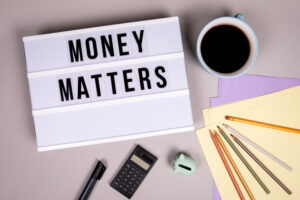 A pile of supplies around a board that reads “money matters.”