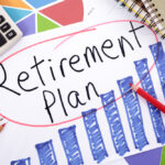 The words “Retirement Planning” circled on a piece of paper, surrounded by other metrics and tools.