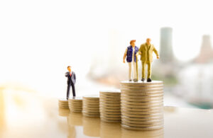 Figurines of a couple walking over a stack of coins.