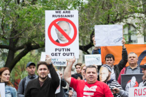 Protestors holding a sign that reads “We are Russians! Putin, get out!”