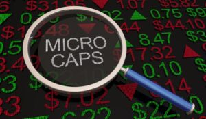 The word “MICROCAPS” shown through a magnifying glass with numbers and data around it.