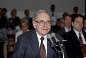 Warren Buffett sitting in front of a microphone.