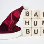 Santa’s hat next to a stack of blocks that reads “bah humbug.”