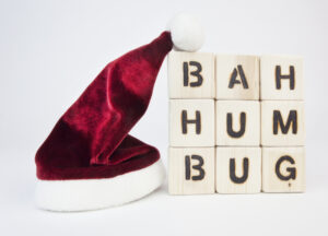 Santa’s hat next to a stack of blocks that reads “bah humbug.”