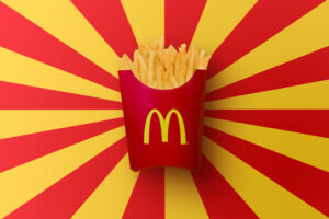 A carton of McDonald’s french fries in front of a yellow and red design.