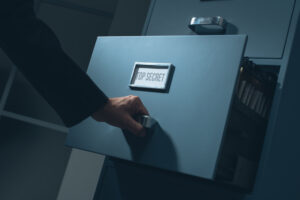 A man opening a drawer in the dark, with the words “top secret” written over the handle.