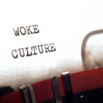 The phrase “woke culture” written on a typewriter.