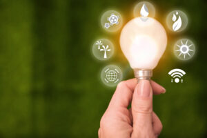 A woman holding a a lightbulb that is surrounded by several different sources of energy.