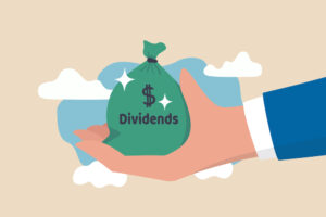 A hand holding a bag that reads “dividends” with clouds in the background.