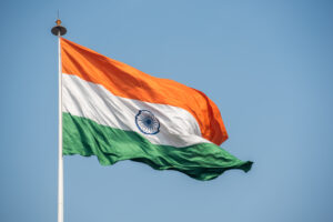 The national flag of India waving in the air on a flagpole.