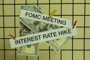 “Interest rate hike” and “FOMC” hanging by clothespins with money in the background.