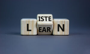 Three wooden cubes that read “listen” and “learn.”