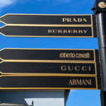 Direction arrows with several luxury brands painted on them.