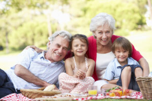 Grandparents with their grandchildren while enjoying a picnic.