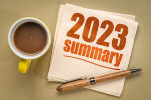 2023 year summary text on a napkin with a cup of coffee.