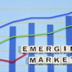 A chart trending upwards with the words “emerging markets” spelled out of tiles.