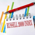 The Russell 2000 Index written on a spiral notebook in front of charts.