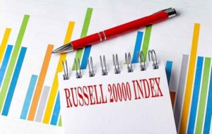 The Russell 2000 Index written on a spiral notebook in front of charts.