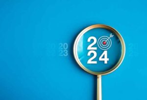 “2024” spelled out inside of a magnifying glass with a bullseye target inside it.