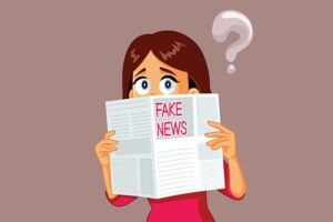 A cartoon woman reading a newspaper that says “FAKE NEWS” on it.