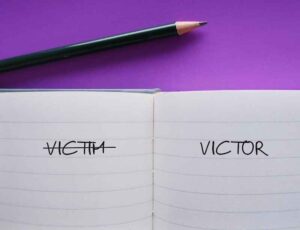 The words “VICTIM” and “VICTOR” written in a journal.