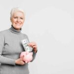 A woman putting money into a piggy bank.